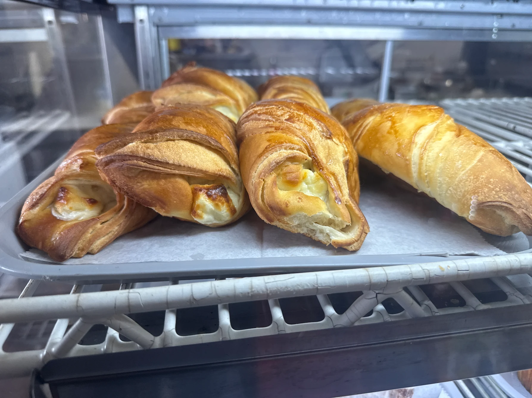 Golden-brown empanadas resting in a warm display case at Continental Market